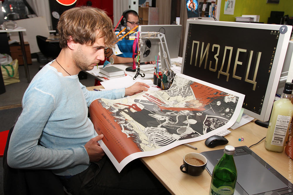 Дизайнер Владимир Павленко рассматривает увеличенную страницу календаря. 